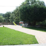 cour avec table de pique-nique, salon de jardin et aire de jeux pour les enfants.